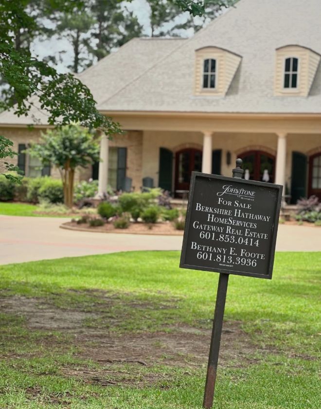 real estate sign in front of a house